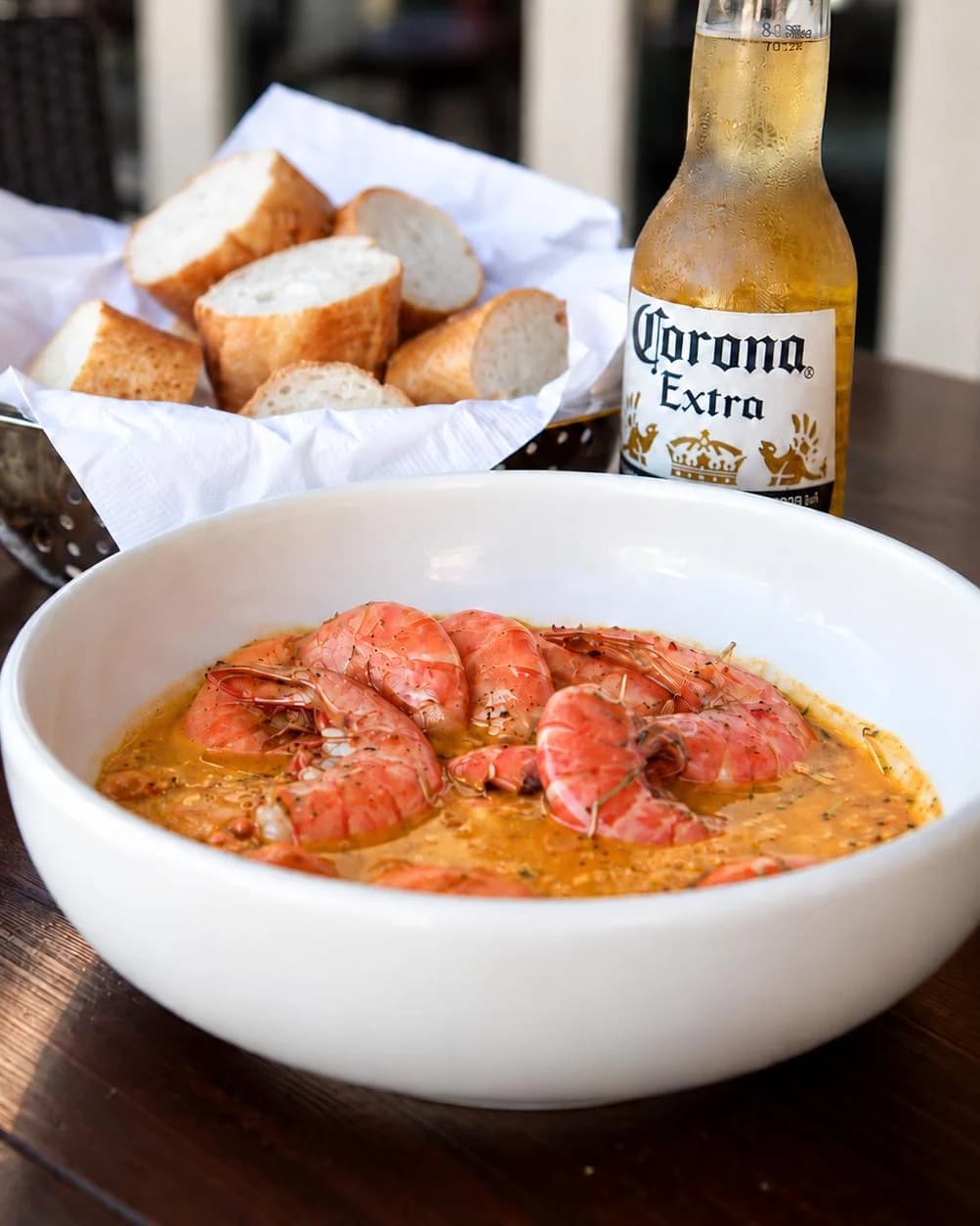 Killer Shrimp Original: a white bowl of shrimp in spicy sauce with French bread and a Corona at Killer Shrimp in Marina del Rey